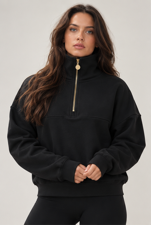 Edge Cozy Half Zip Sweater i svart forfra, høy krage og gullfarget glidelås ned til brystet.
