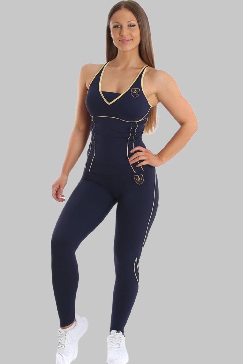 Modellen står i marineblå singlet og marineblå tights med gullinjer, til hvite sneakers.