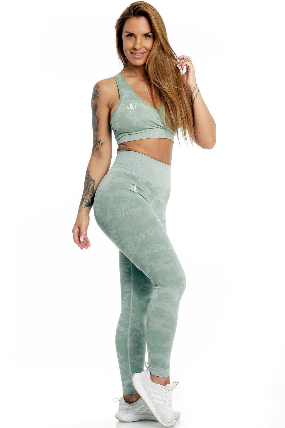 Modellen står i den mintgrønne toppen og kamuflasjemønstrede tights, til hvite sko.