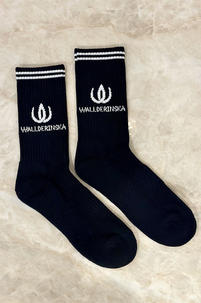 Sokkene ligger side om side og viser den hvite logoen i ribbestrikken.