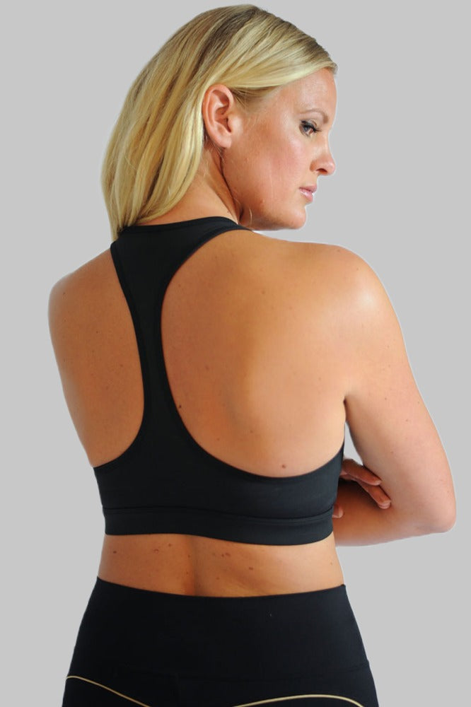 Racerbackryggen på den svarte toppen, båret til svarte tights med gullfarget kant.
