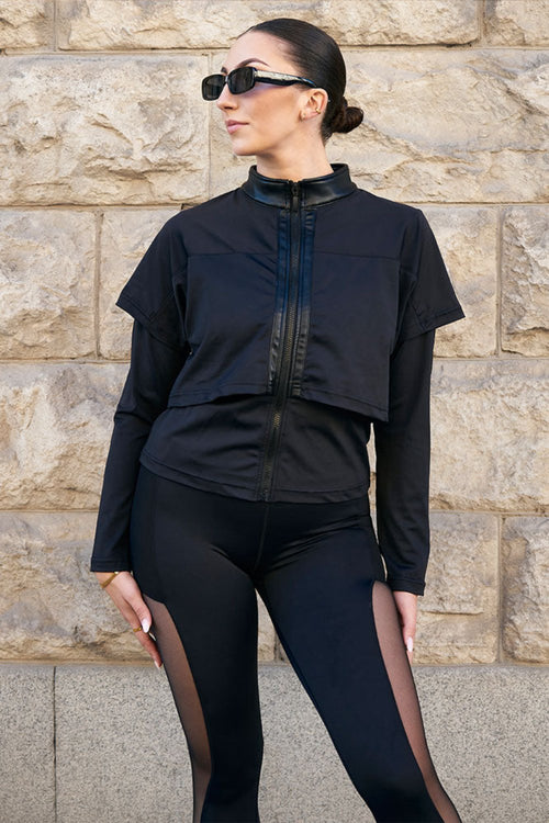 Edge Svart Treningsjakke med blank krage og lag over skuldrene, til svarte tights med mesh.