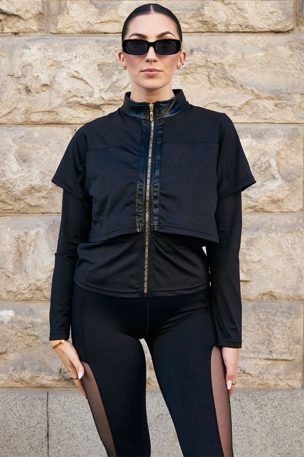 Edge Treningsjakke Gold Zip med gullfarget glidelås rett foran, til svarte tights med mesh.