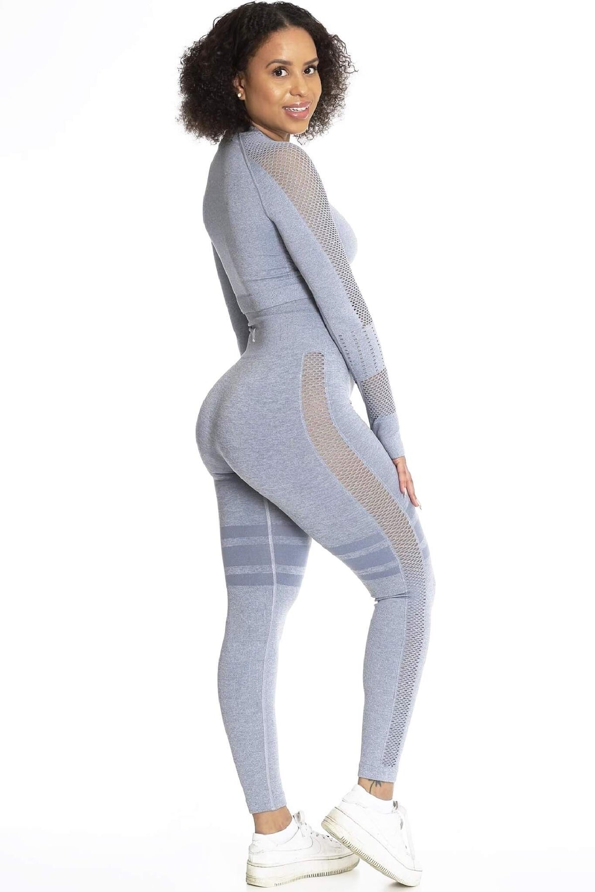 Genseren bæres til matchende grå tights og hvite sneakers. Modellen ser over skulderen.